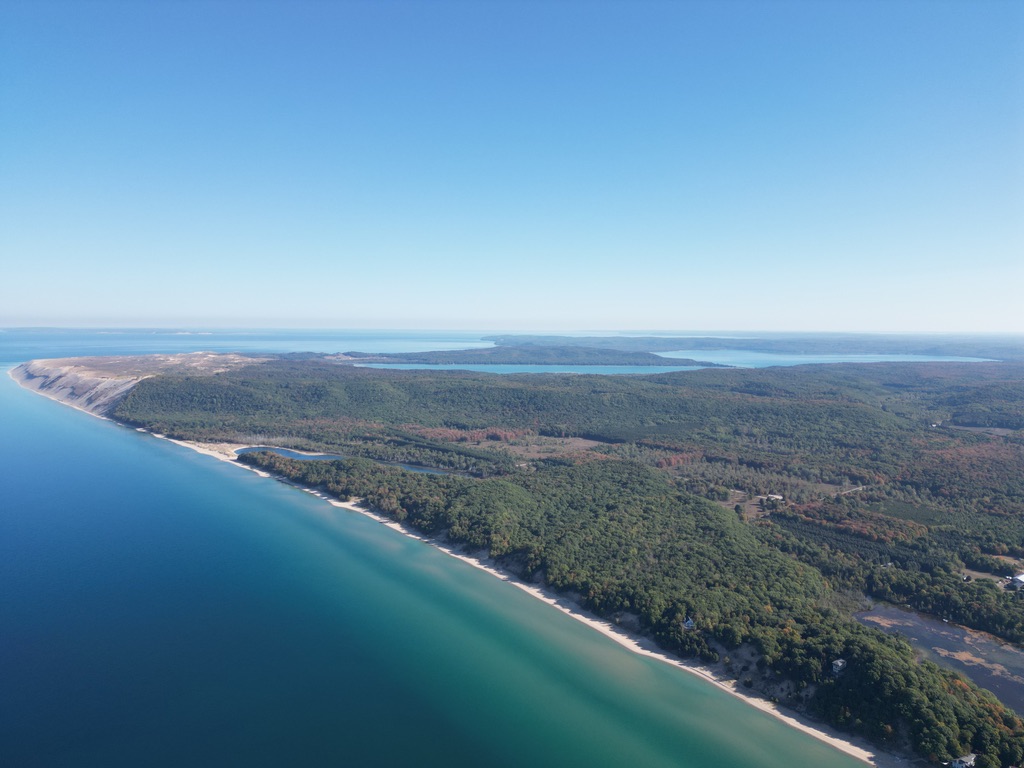 My drone’s view of a forested coastline, sandy bluffs, and blue lakes stretching toward the horizon.